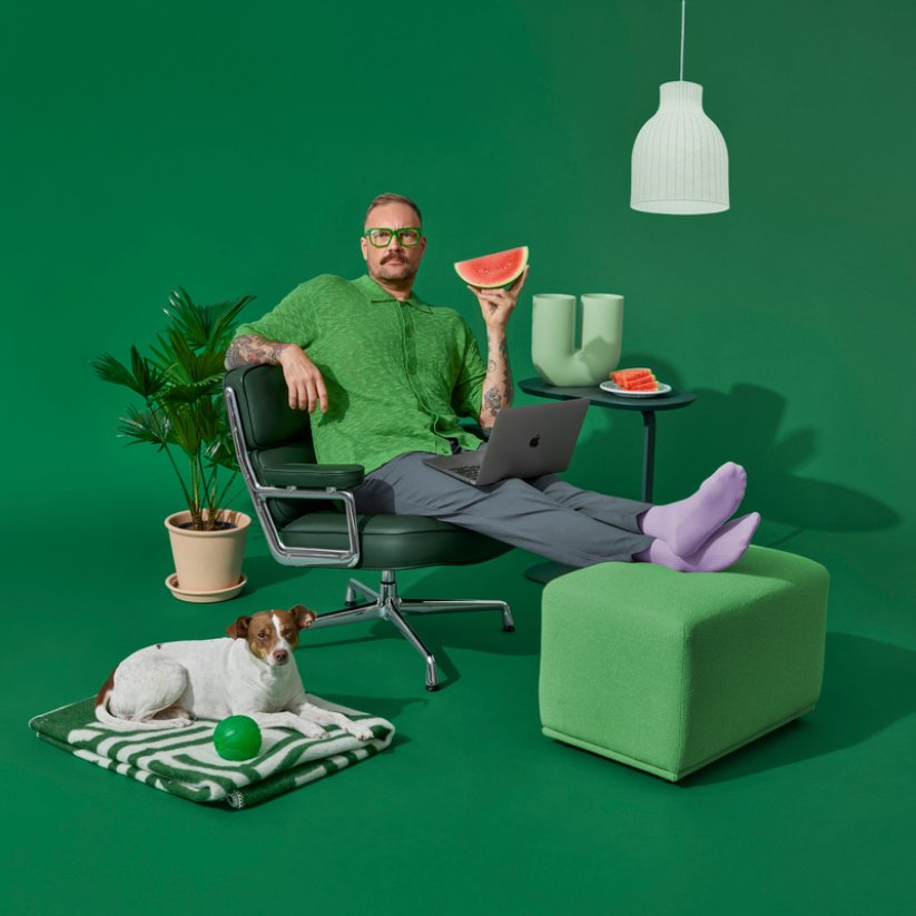 Man sitting in a chair, with a dog lying next to him on the floor