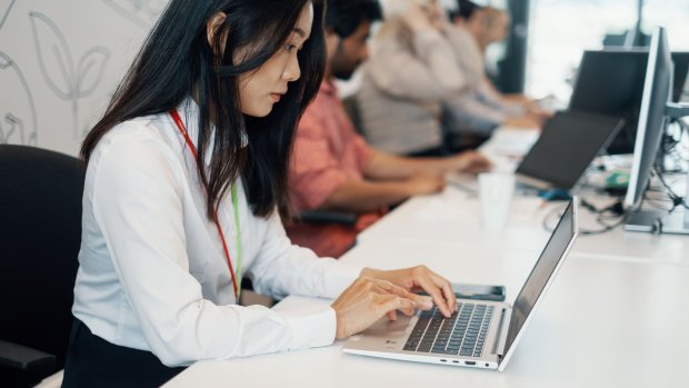 A woman is writing on her PC.