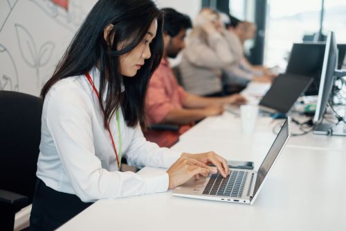 A woman is writing on her PC.