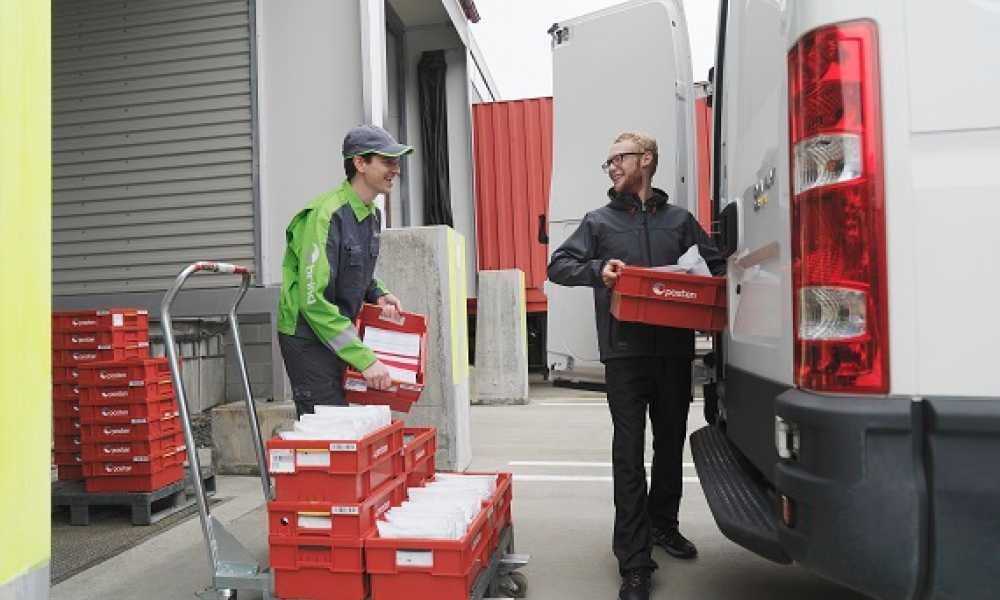 Two men loading a truck with mail