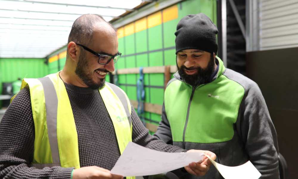 Two male Bring employees looking at a sheet of paper
