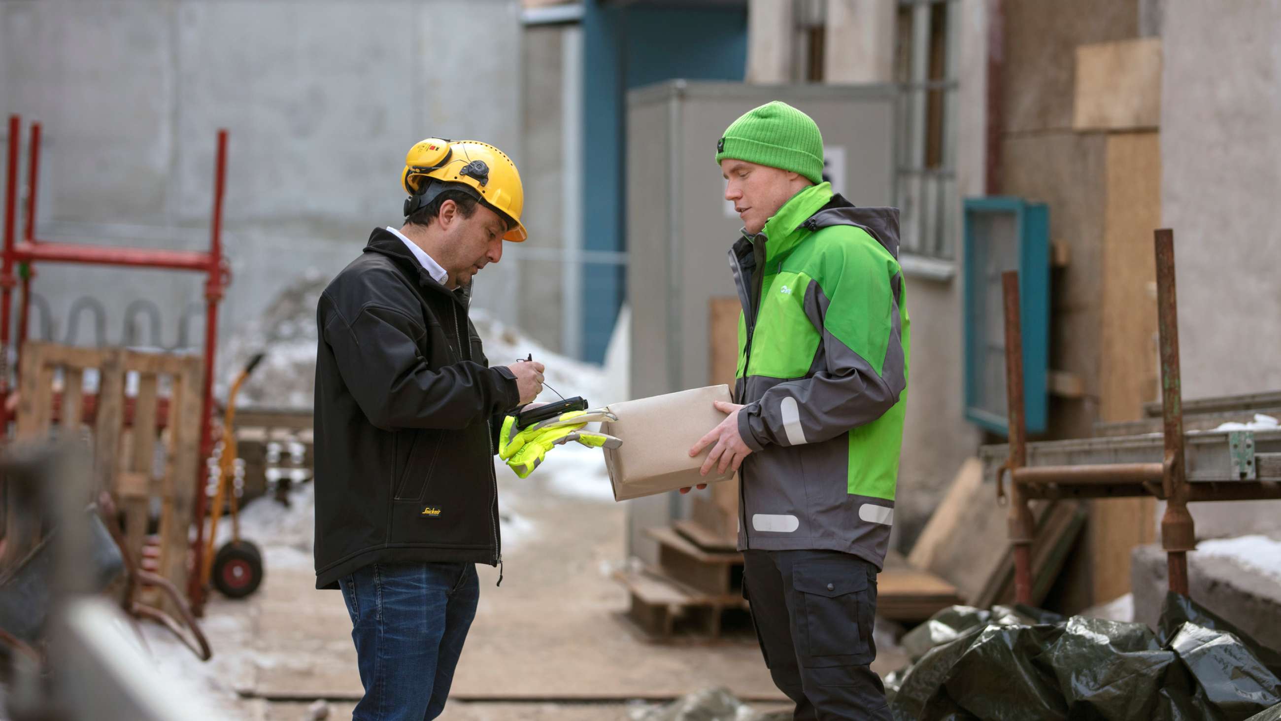 A Bring delivery man delivering a parcel at a construction area