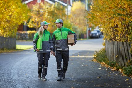To bud i Bring-uniform som har har en pakke under hver sin arm.