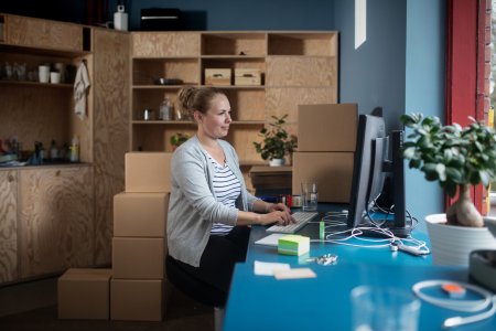 En kvinne som sitter på et kontor og jobber