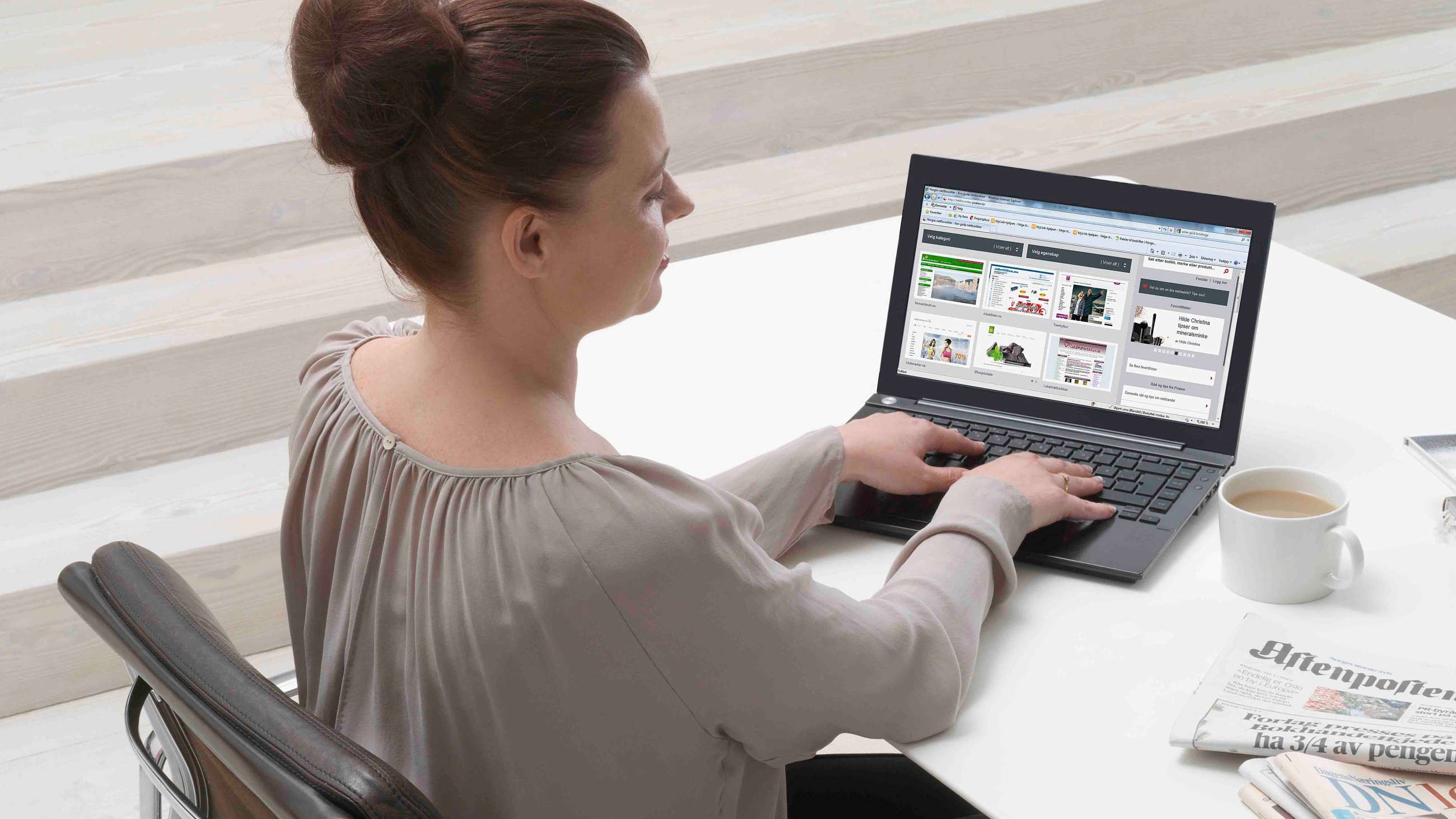 En kvinne som jobber på en svart laptop