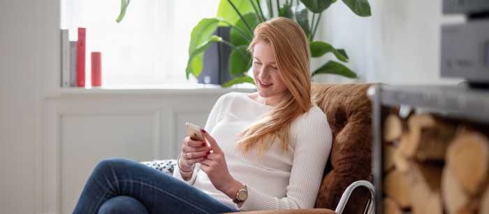 En kvinne som surfer på mobiltelefonen sin.