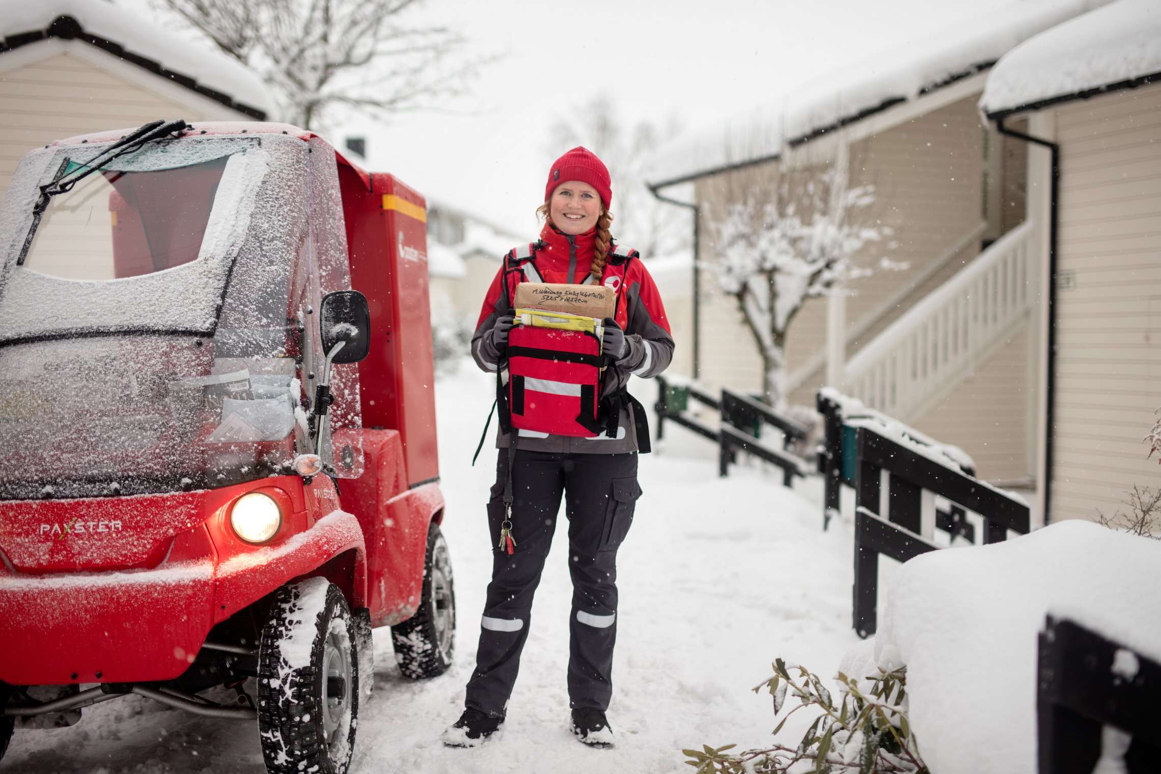 Postbud leverer pakker i Paxter elbil