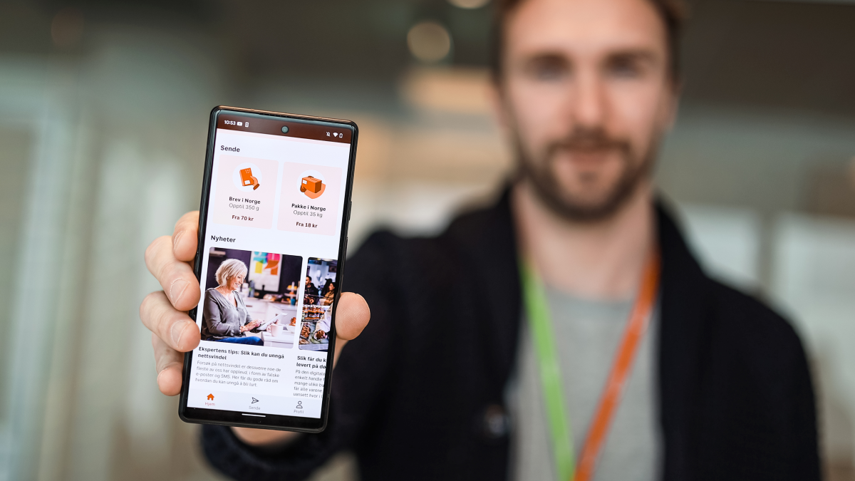Mann som holder en telefon som viser Posten-appen.