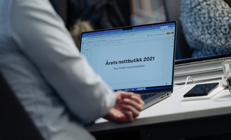 Laptop med skjermbilde med tekst "Årets Nettbutikk"