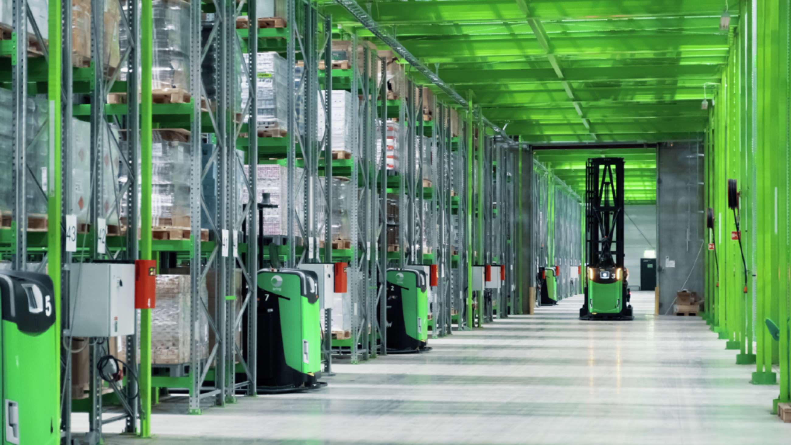 Shelfless lager på Berger viser oppbevaring av hyller og en robot truck som står med lysene på. 