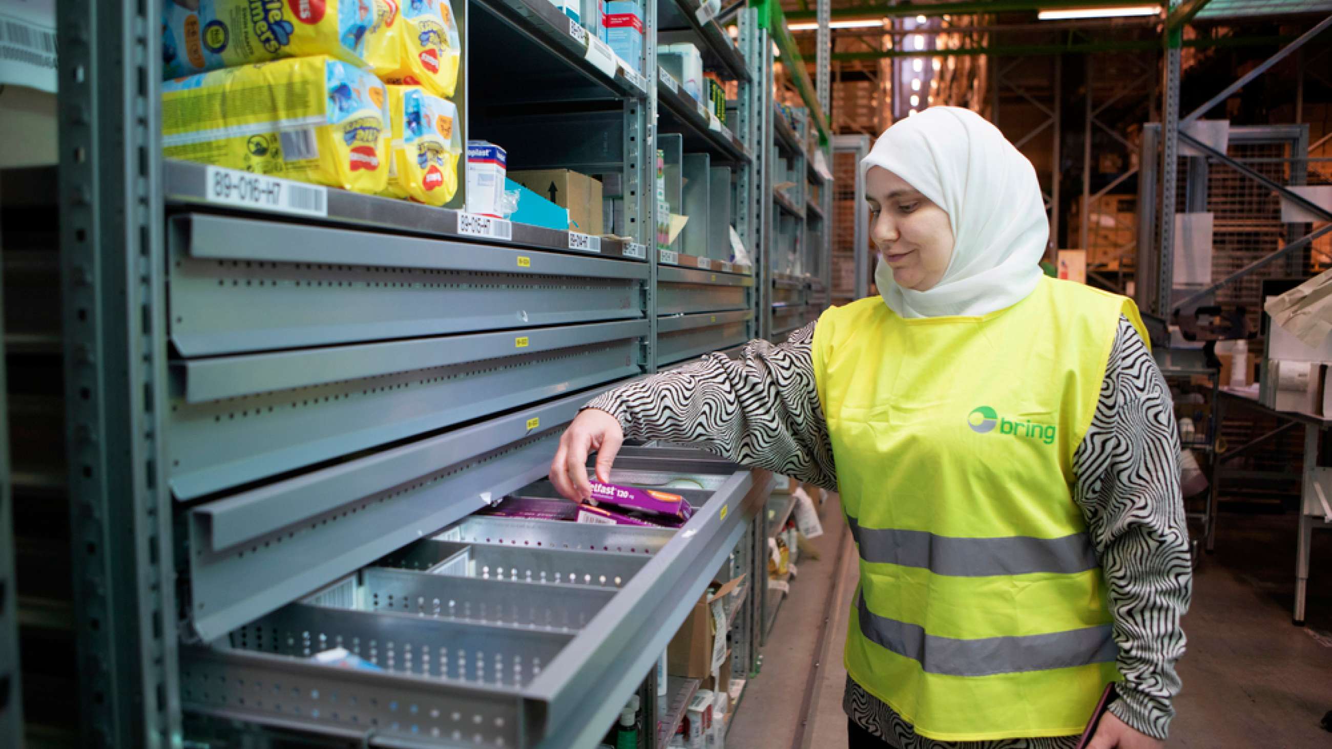 En dame fraa nettapoteket Apotekia viser hvordan reseptfrie varer oppbevares hos Shelfless. 