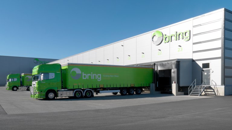 Grønne bring-trailere laster gods på bring terminal.