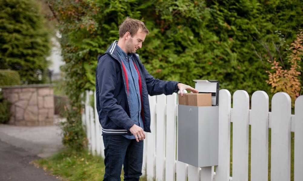 Mann henter pakke fra postkassen.