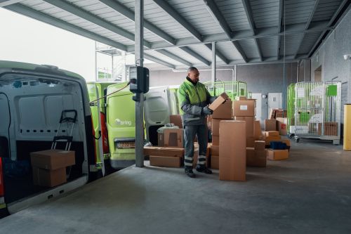 bringsjåfør sorterer pakker på rampe.
