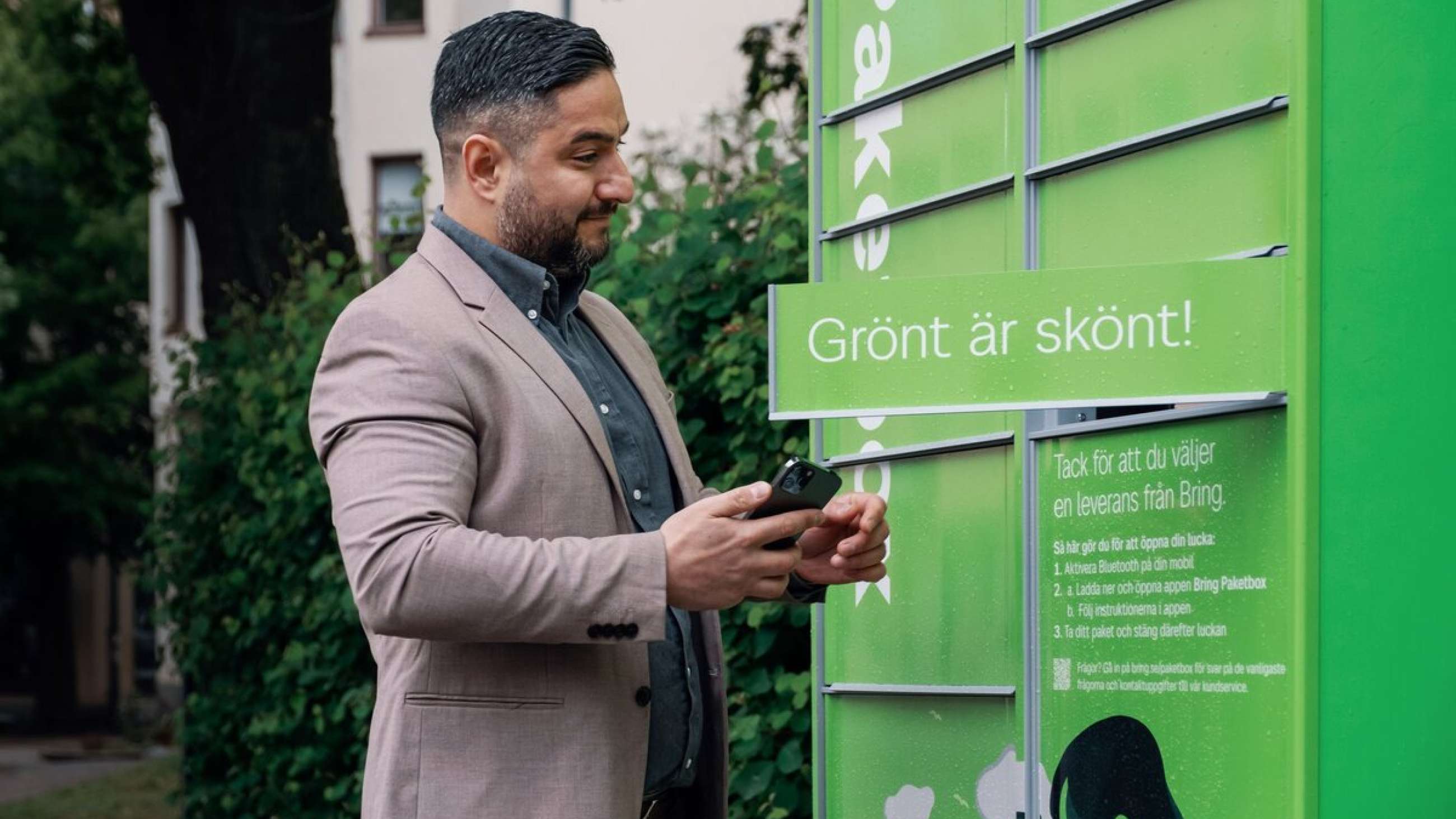 Mann åpner en grønn pakkeboks