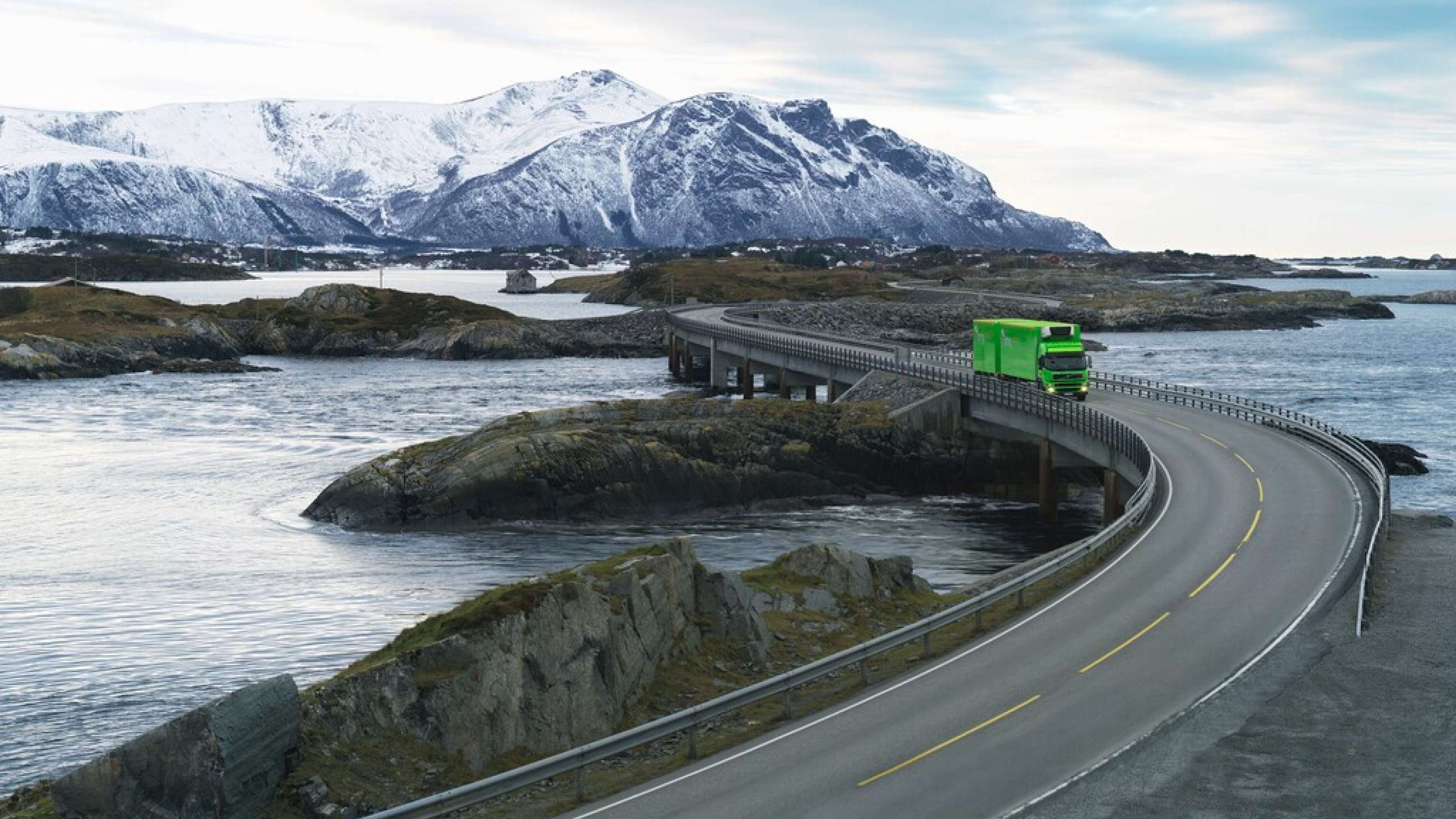 En Bring-lastebil som kjører på Atlanterhavsveien med fjell i bakgrunnen